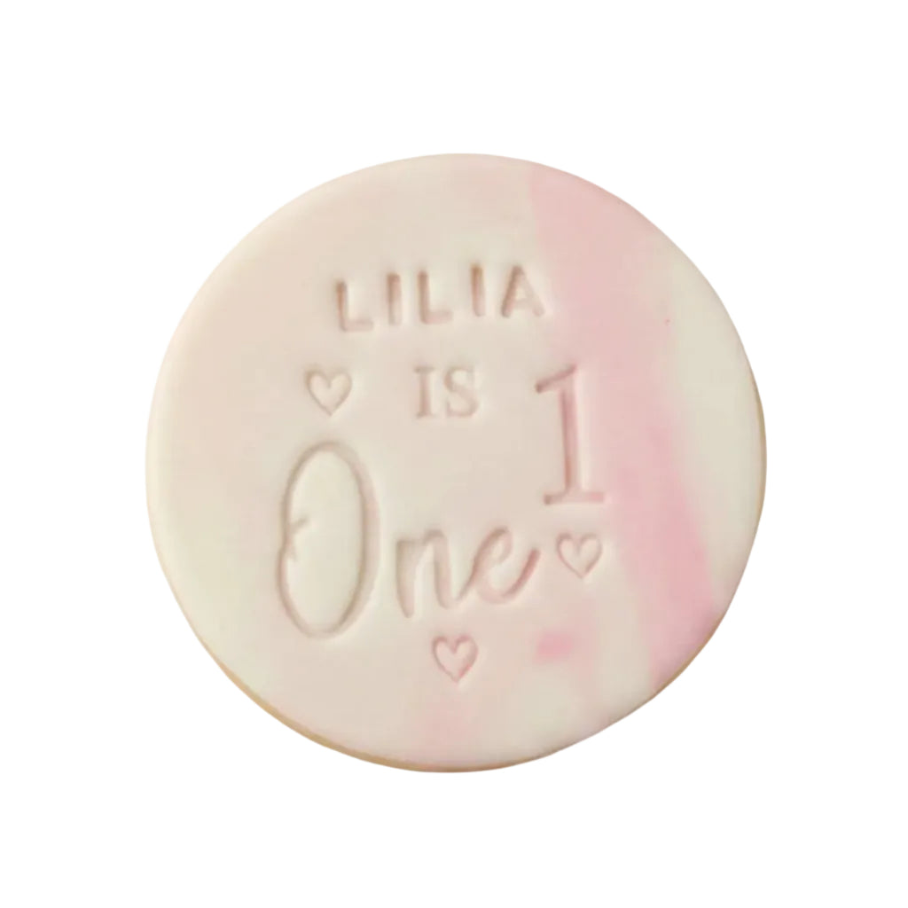Personalised first birthday round white signature vanilla sugar biscuits. Each biscuit is embossed with the name, marble fondant.