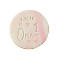 Personalised first birthday round white signature vanilla sugar biscuits. Each biscuit is embossed with the name, marble fondant.