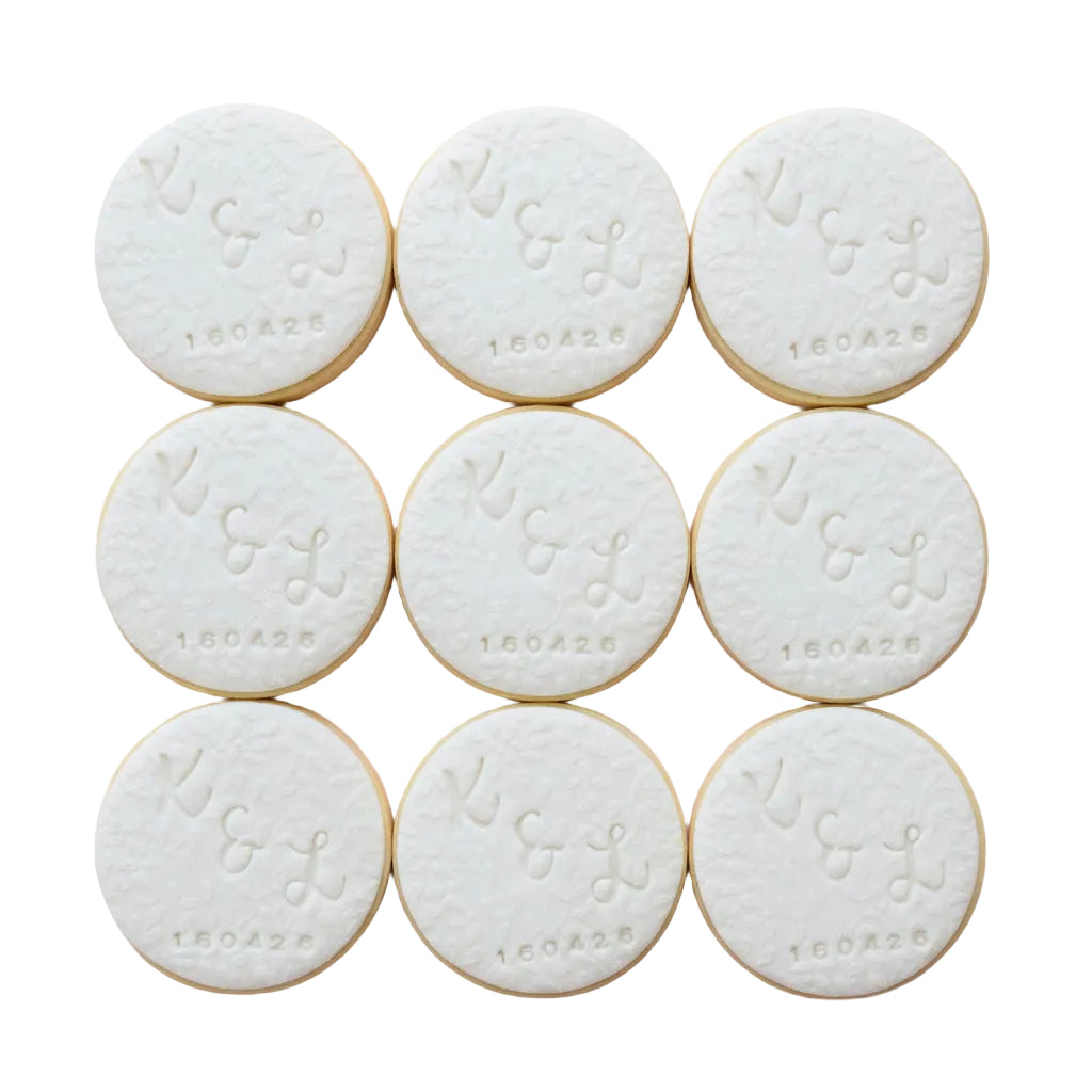 Personalised engagement round white signature vanilla sugar biscuits. Each biscuit is embossed with a monogram design and the date.